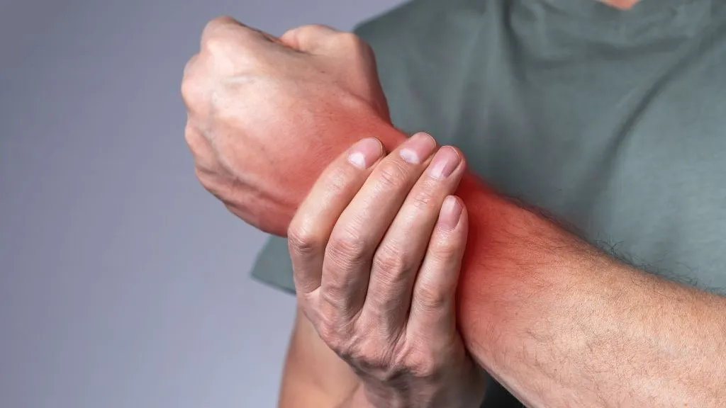 Man with hand agony, rabing his hand.