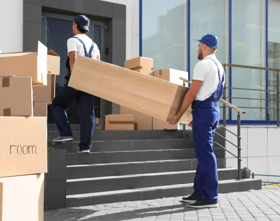 Two men ascend steps with boxes outside a building, illustrating the practicality of affordable moving services.