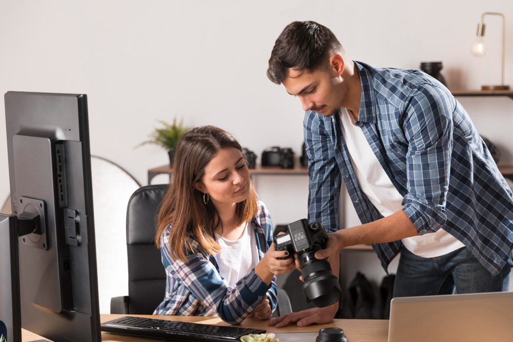 A man and woman focus on a computer, exploring options for liability insurance tailored for artisan contractors and photographers.