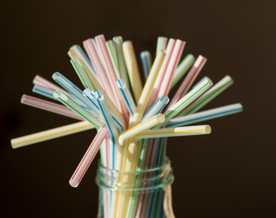 A glass jar filled with vibrant, eco-friendly straws, promoting sustainable practices for businesses in New York.