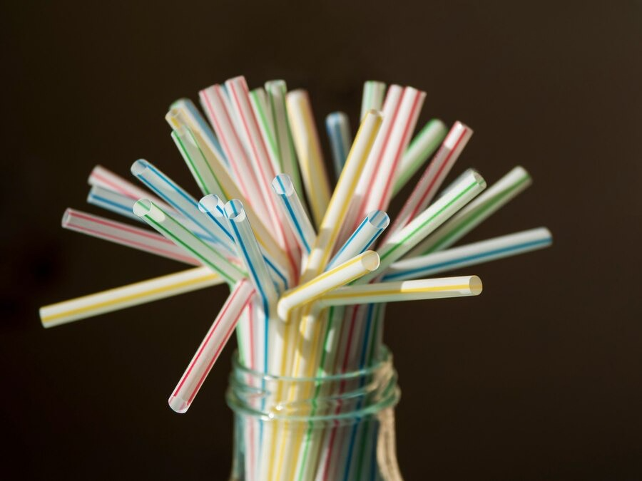 A glass jar filled with vibrant, eco-friendly straws, promoting sustainable practices for businesses in New York.